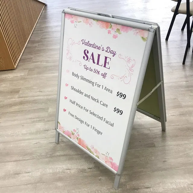 A-frame sign holder for posters, displaying promotional material.